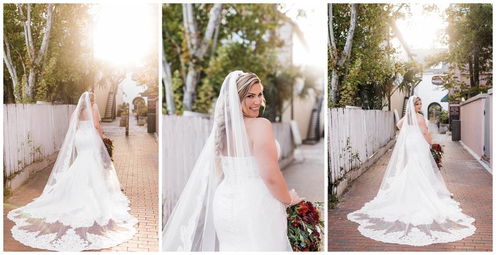 Bride wearing mermaid style wedding dress with long train wedding veil looking over her shoulder at the The White Room in St. Augustine, Florida. Photography by Captured By Lau Photography, a St. Augustine, Florida Wedding Photographer.