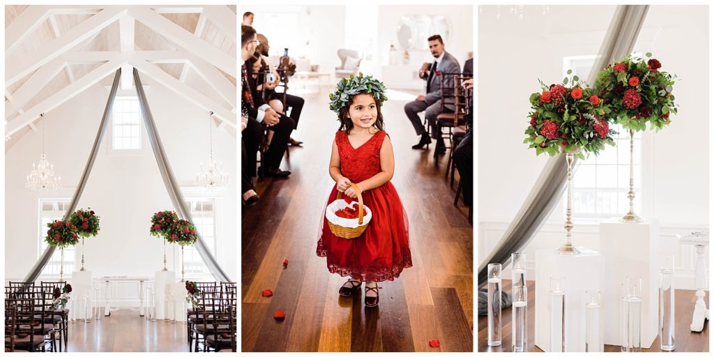 Flower girl in red dress and red floral arrangements at the The White Room in St. Augustine, Florida. Photography by Captured By Lau Photography, a St. Augustine, Florida Wedding Photographer.