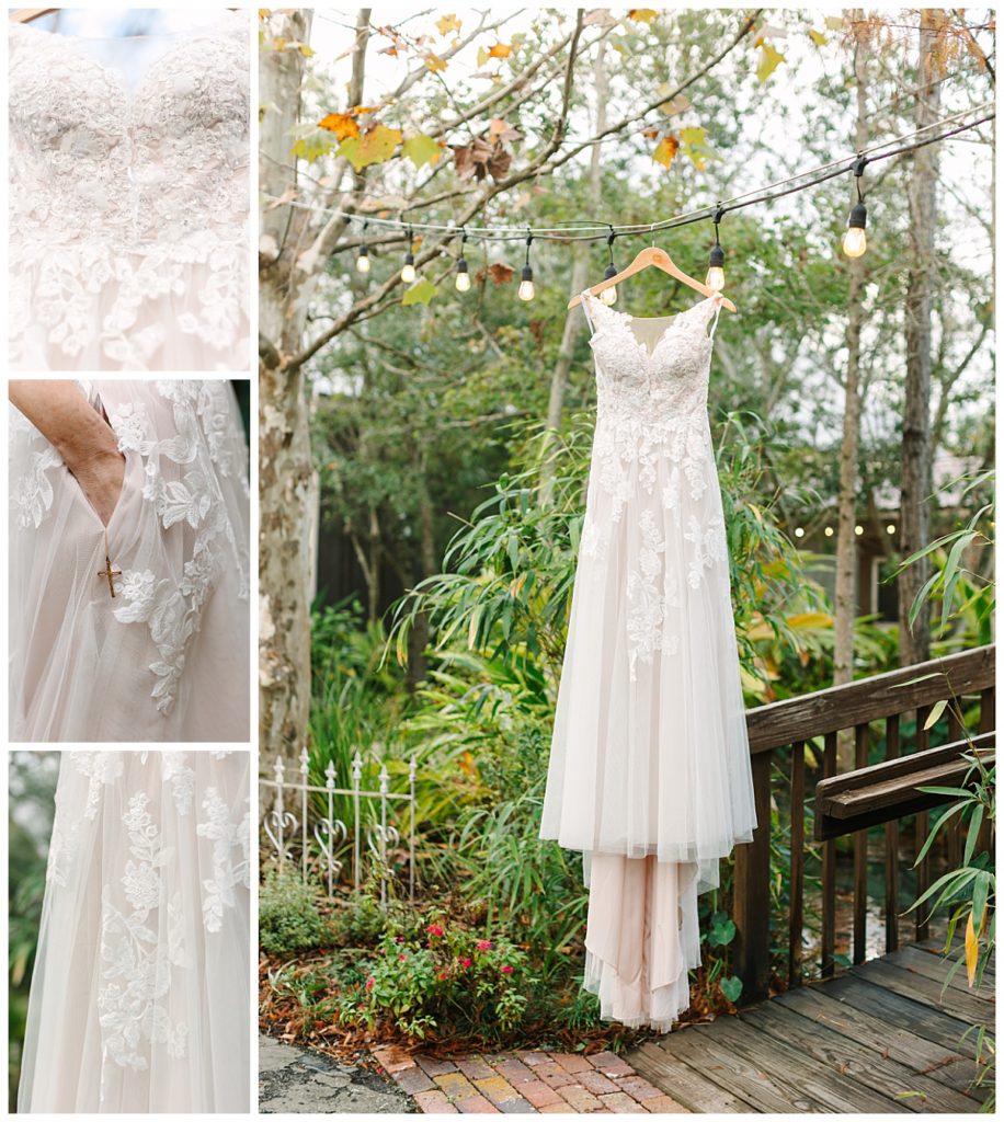 A lace wedding gown hangs in front of a background of greenery in St. Augustine, Florida. 