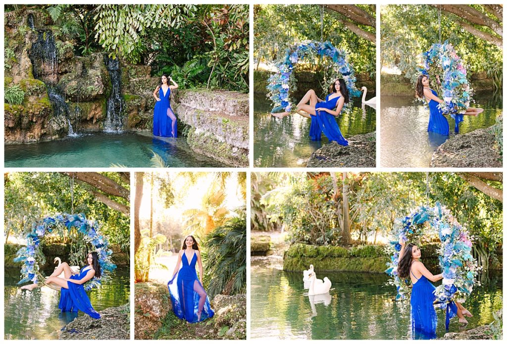 A young woman in a royal blue gown seated on a floral swing overlooking a lagoon next to a waterfall during her quince session at Secret Gardens Miami.