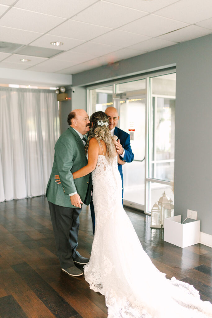 PALM COAST WEDDING
JACKSONVILLE WEDDING PHOTOGRAPHER LAURA PEREZ PHOTOGRAPHY CAPTURES BRIDE AND BOTH HER DAD AND GROOMS DAD HUGGING AFTER A FIRST LOOK WITH BOTH DADS. 