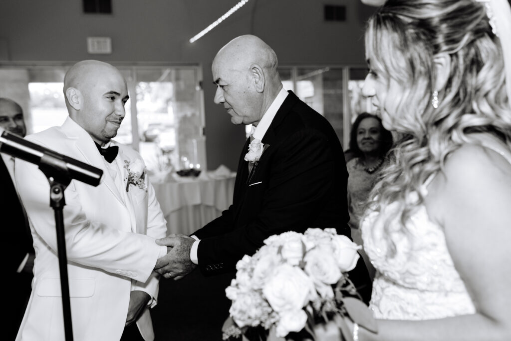 father of the bride handing her off. JACKSONVILLE WEDDING PHOTOGRAPHER. CHANNEL SIDE VENUE IN PALM COAST 