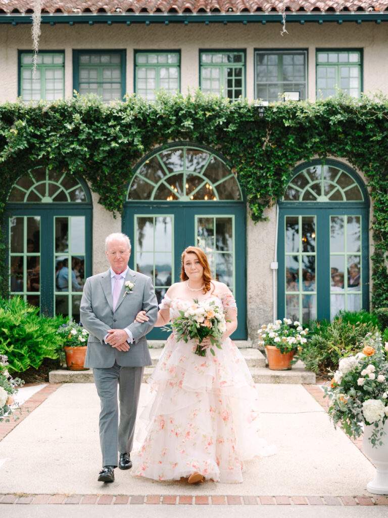 legant riverfront wedding at The Club Continental in Jacksonville, Florida, featuring a couple in the garden surrounded by Spanish-style architecture and lush greenery
