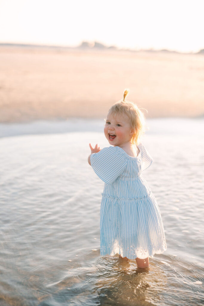 Expecting family embracing during a golden hour maternity photography session at Vilano Beach in St. Augustine, Florida.