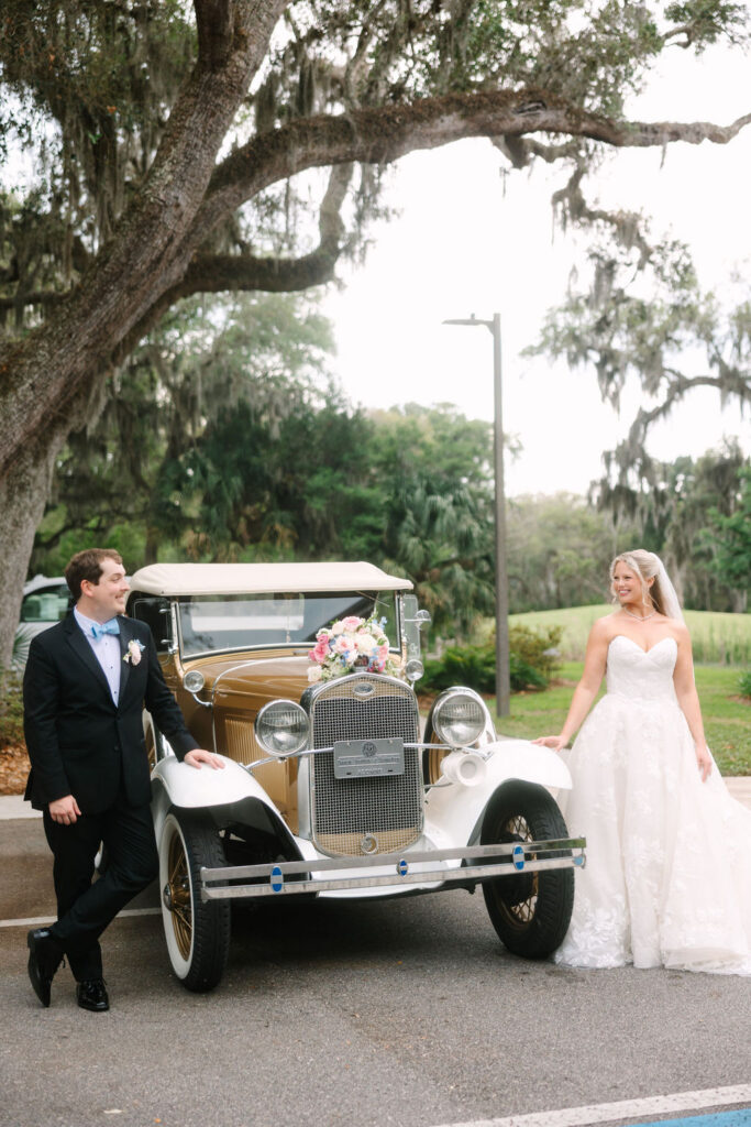 Bride and groom with a vintage getaway car at The Oaks at Amelia Island wedding venue in Fernandina Beach, Florida.