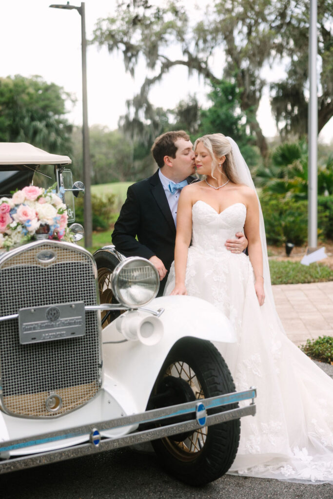 Bride and groom with a vintage getaway car at The Oaks at Amelia Island wedding venue in Fernandina Beach, Florida.